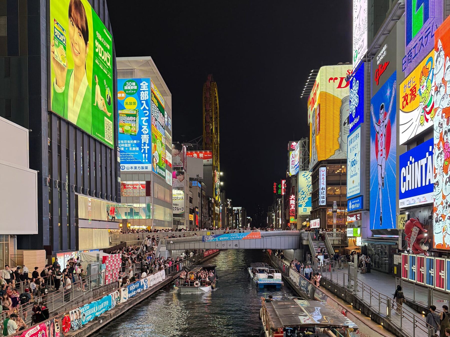 Illuminated signs and sightseeing boats along the Dōtonbori canal in Osaka