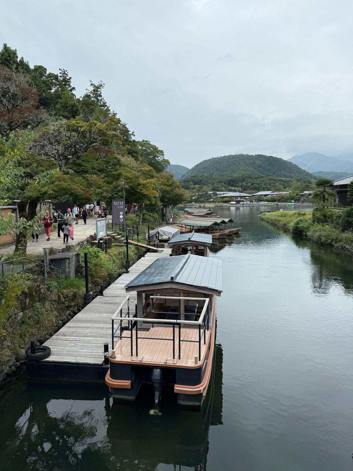 Traditional sightseeing boats moored along a calm river in Arashiyama