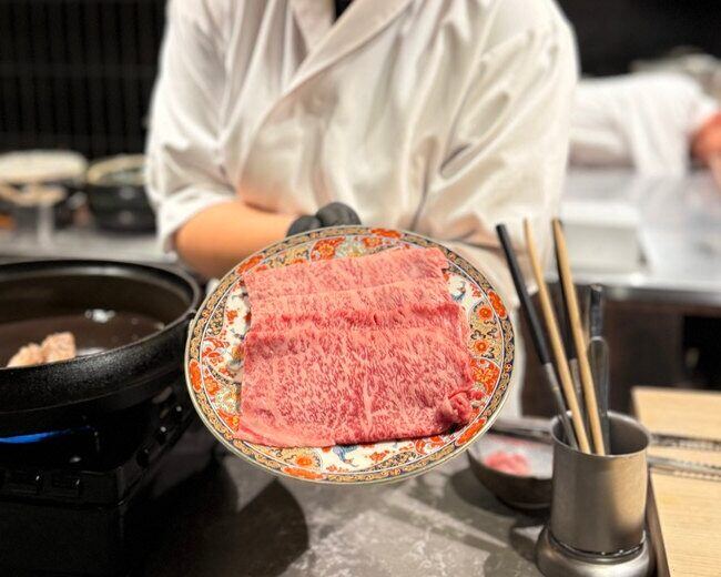 A richly marbled cut of Japanese beef presented on a patterned plate