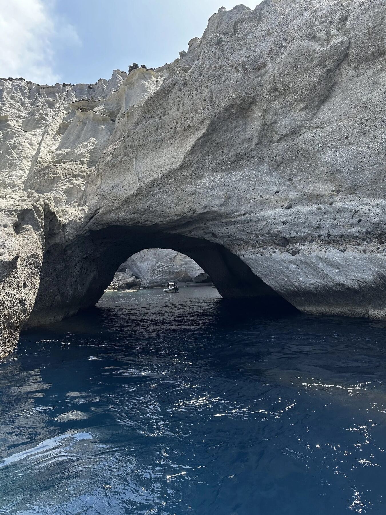 A natural coastal arch above clear blue water